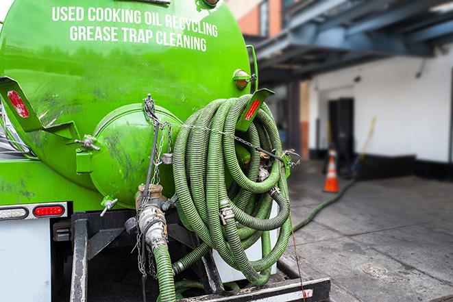 a technician pumping a grease trap in a commercial building in Trail Creek